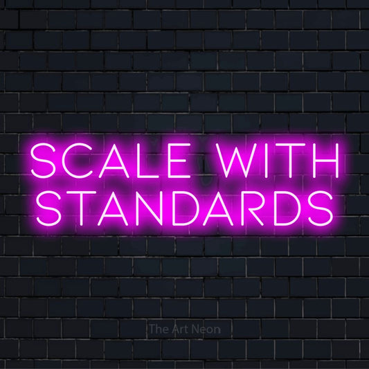 "Scale With Standards" glowing LED neon sign on a black brick wall