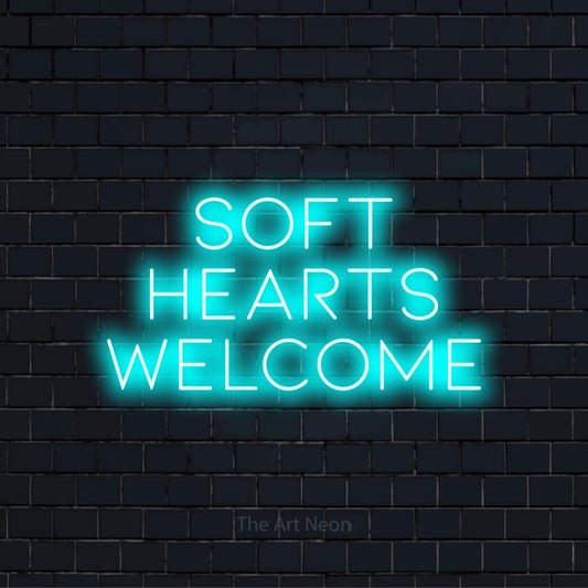 "Soft Hearts Welcome" text design with neon effect on a black brick wall