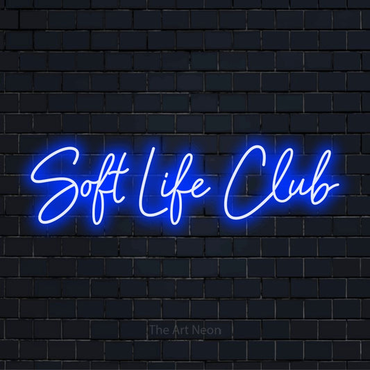"Soft Life Club" LED neon sign on a black brick wall