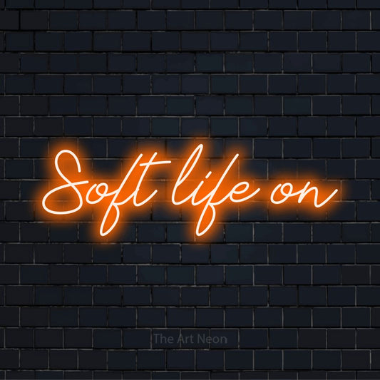 "Soft Life On" LED neon sign on a black brick wall