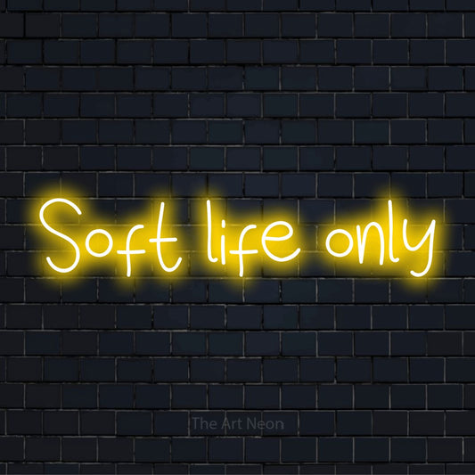 "Soft Life Only" neon text design on a black brick wall