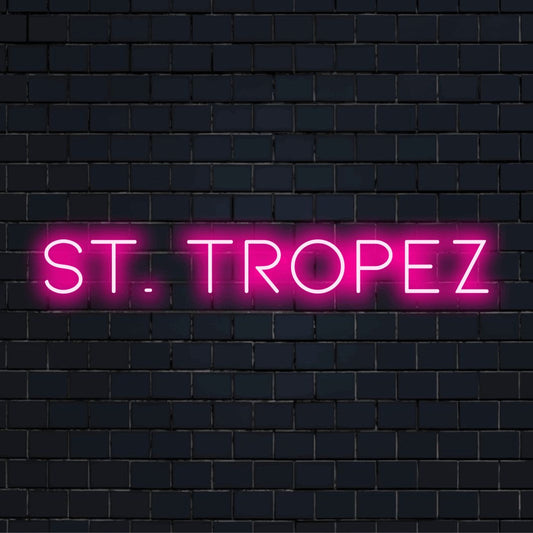 St Tropez Neon Light with bright neon glow on black brick background