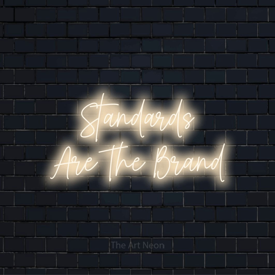"Standards Are The Brand" text design with neon effect on a black brick wall