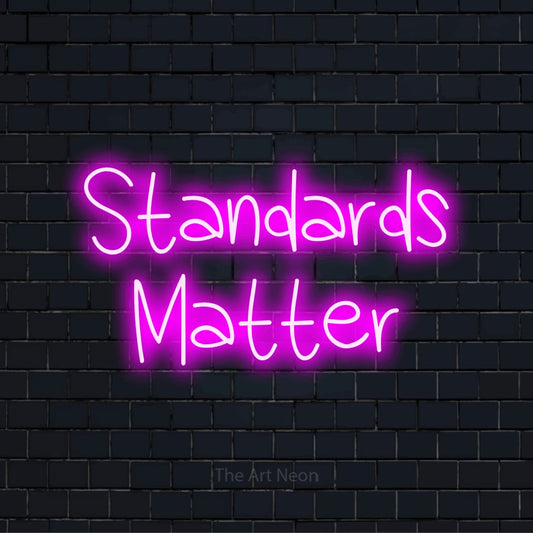 "Standards Matter" text design with neon effect on a black brick wall