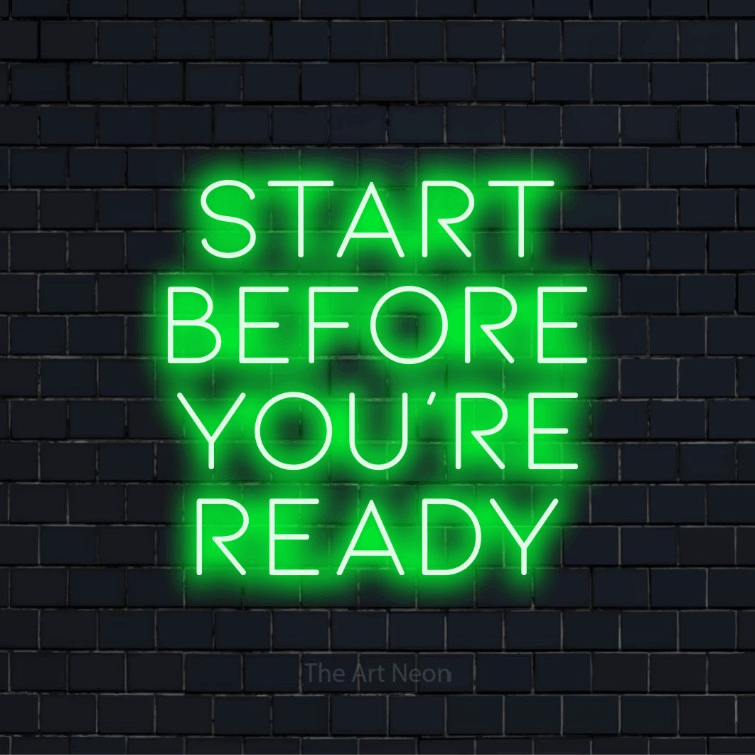"Start Before You’re Ready" glowing LED neon sign on a black brick wall