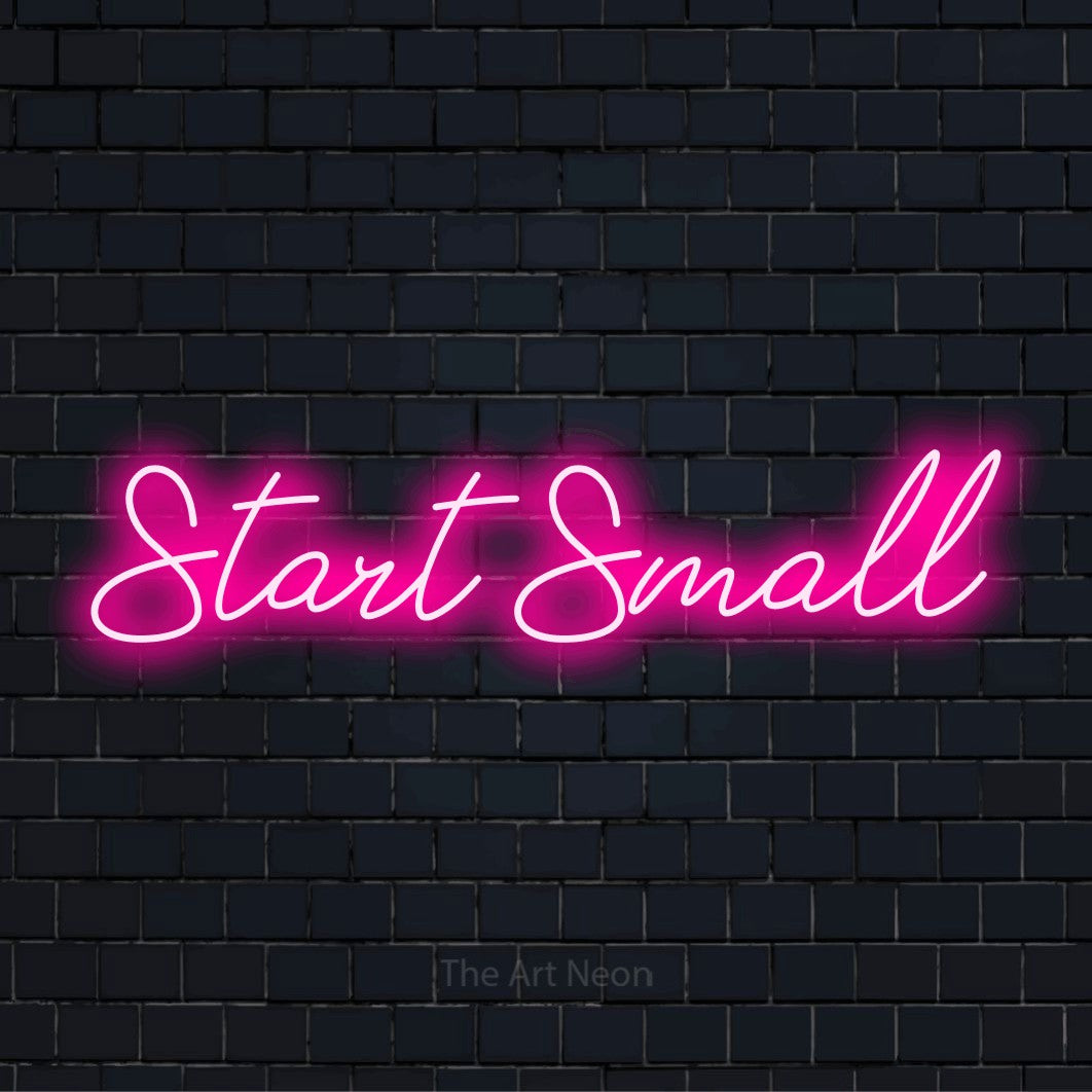 "Start Small" neon text design on a black brick wall