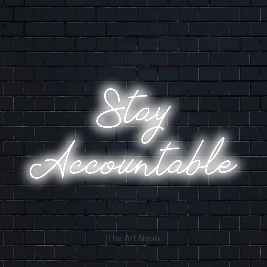 "Stay Accountable" glowing LED neon sign on a black brick wall