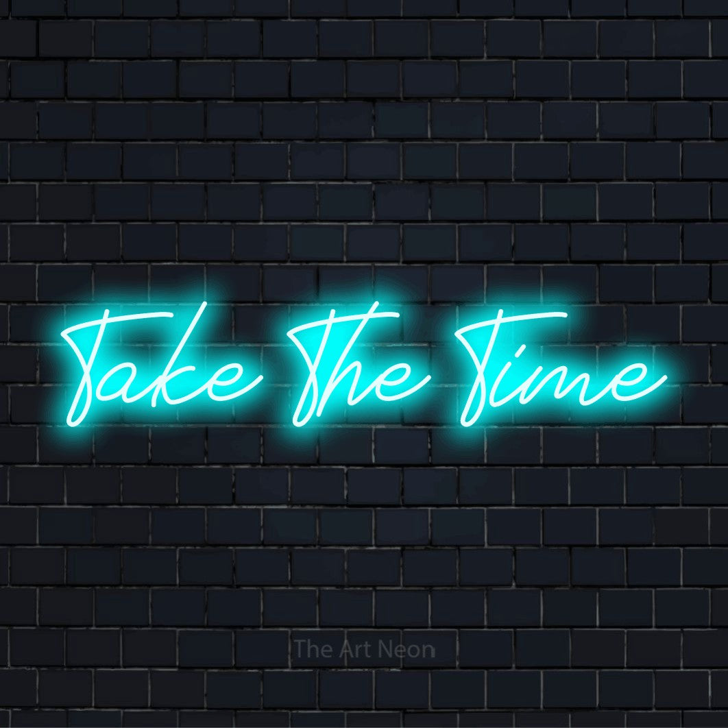 "Take The Time" LED neon sign on a black brick wall