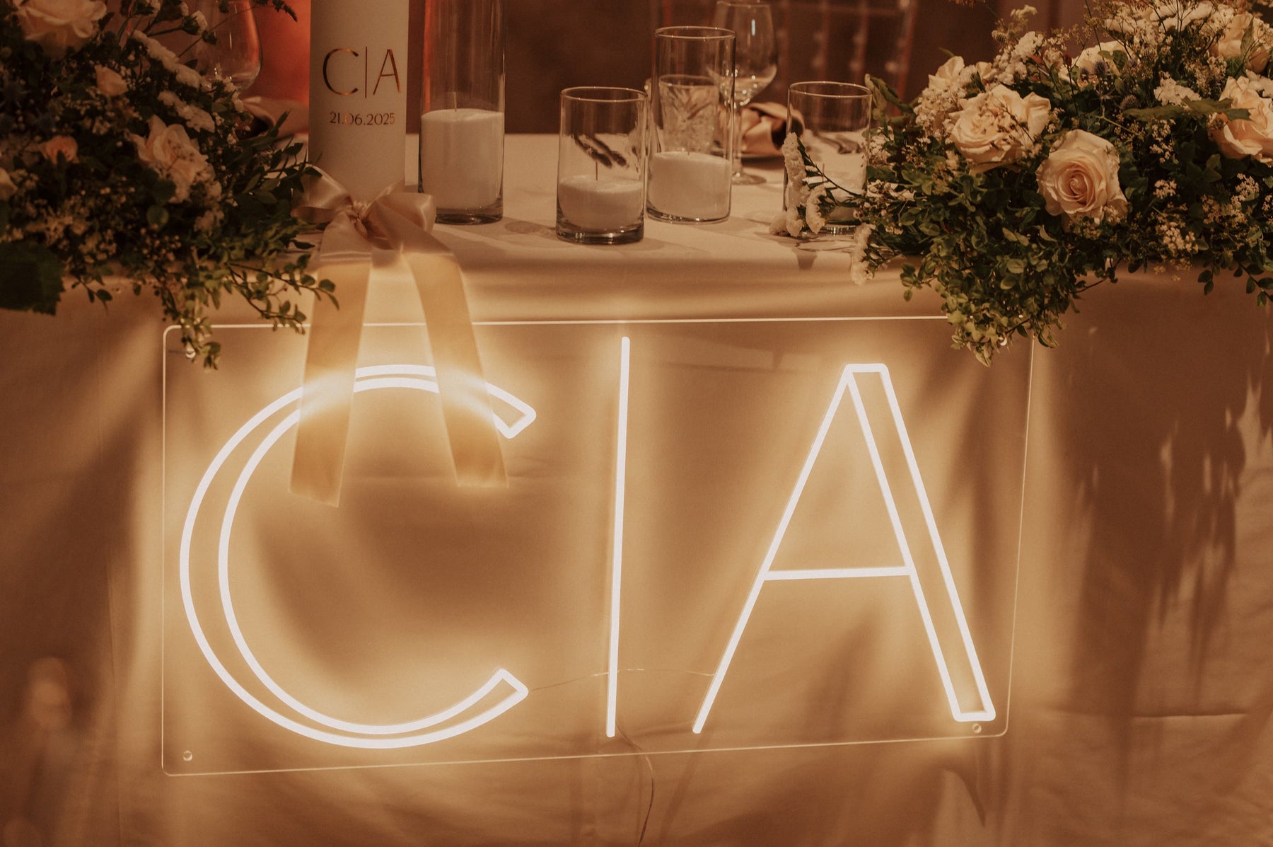 Warm-white C and A initials LED neon displayed on a table for a wedding celebration.