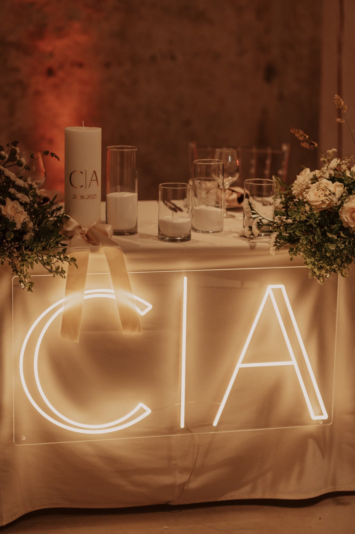 De initialen C en A in warmwit LED-neon op een tafel tijdens een huwelijksfeest.