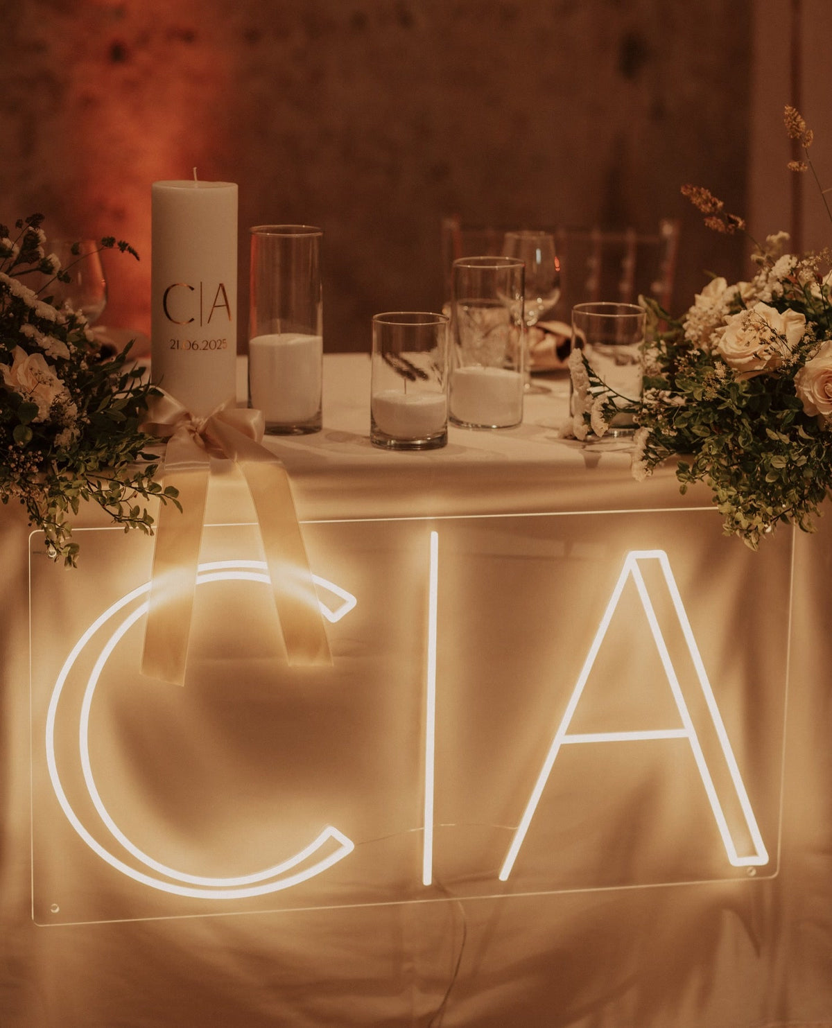 De initialen C en A in warmwit LED-neon op een tafel tijdens een huwelijksfeest.