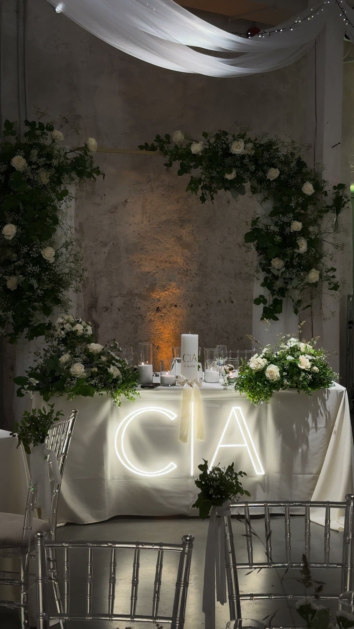 De initialen C en A in warmwit LED-neon op een tafel tijdens een huwelijksfeest.