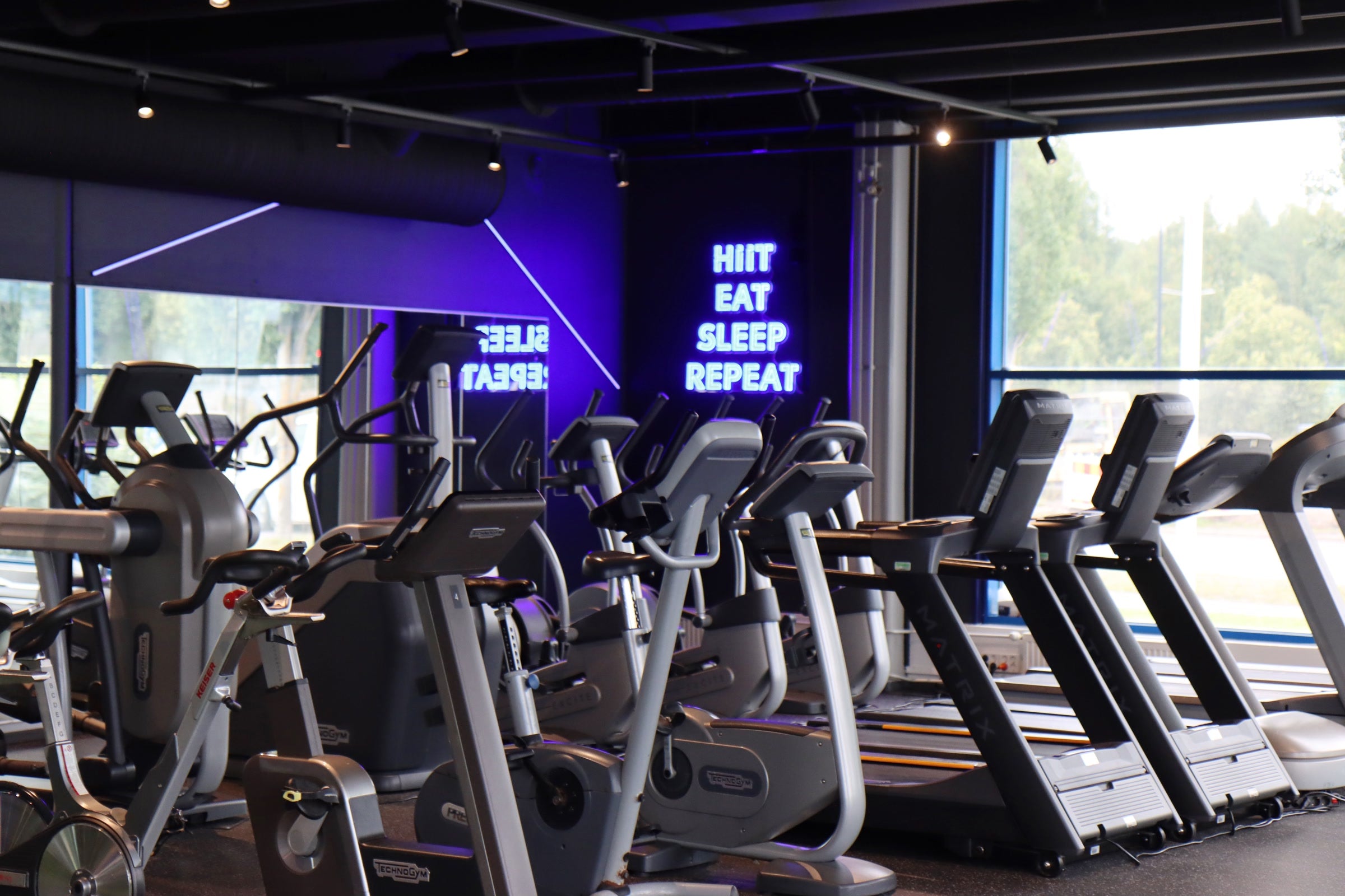Blue HIIT EAT SLEEP REPEAT LED neon sign inside Kuntomaailma gym in Jyväskylä