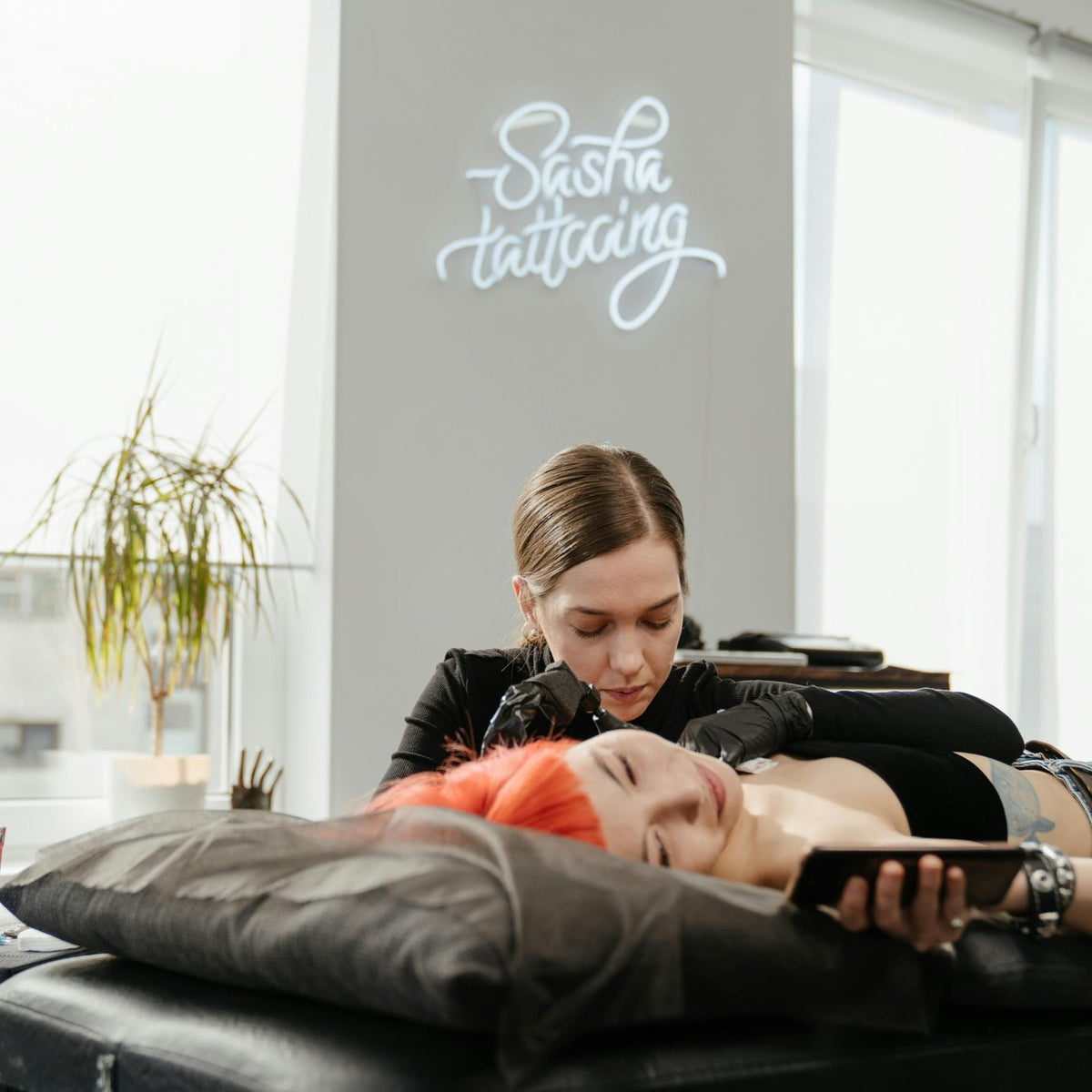 Tattoo artist logo LED neon sign installed in a tattoo studio