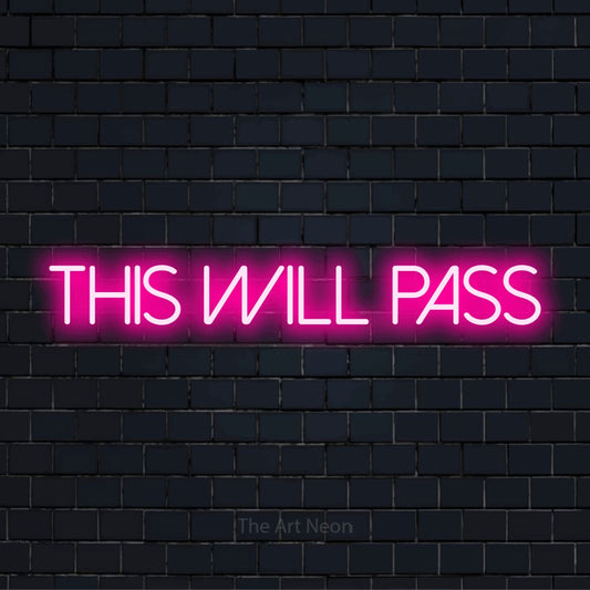 "This Will Pass" LED neon sign on a black brick wall