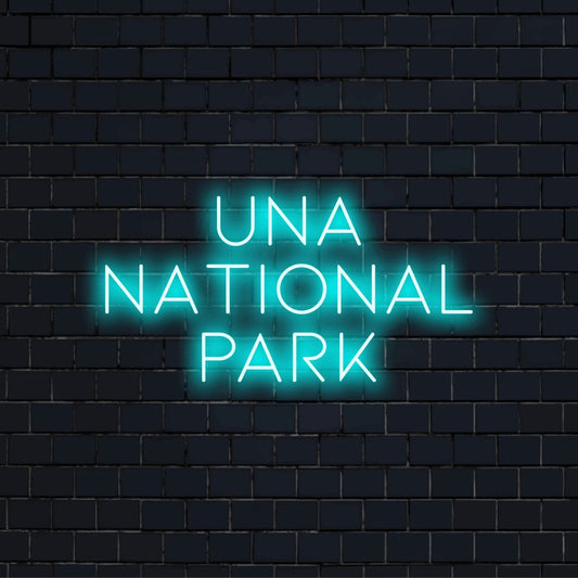 Una National Park Neon Light with bright neon lettering on dark brick background