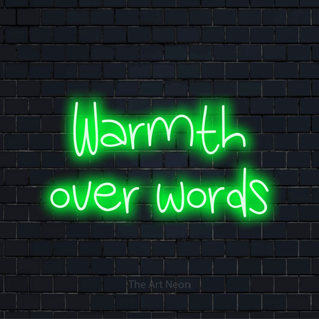 "Warmth Over Words" LED neon sign on a black brick wall